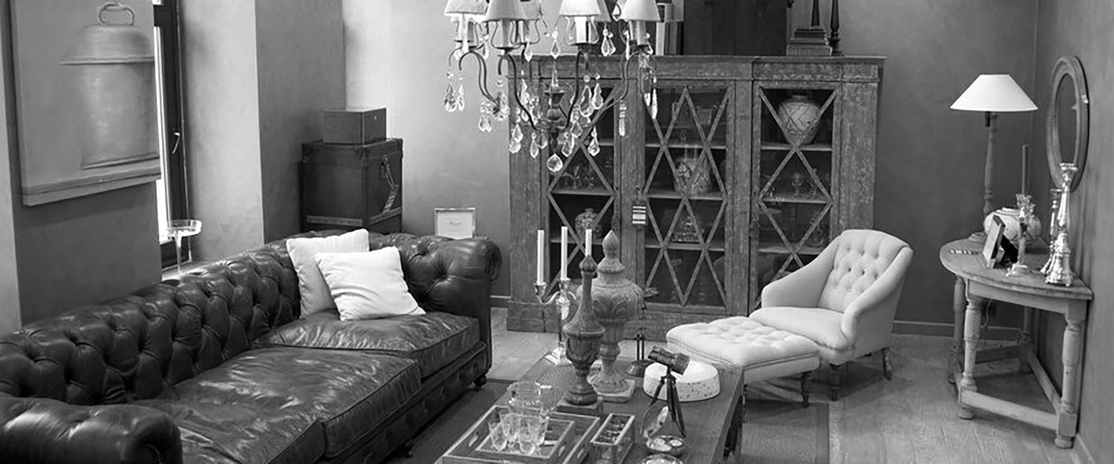 life-style_1122-1801 Elegant living room interior featuring a leather sofa, tufted chaise lounge, vintage wooden cabinet, and chandelier, showcasing luxury home decor with a classic touch.