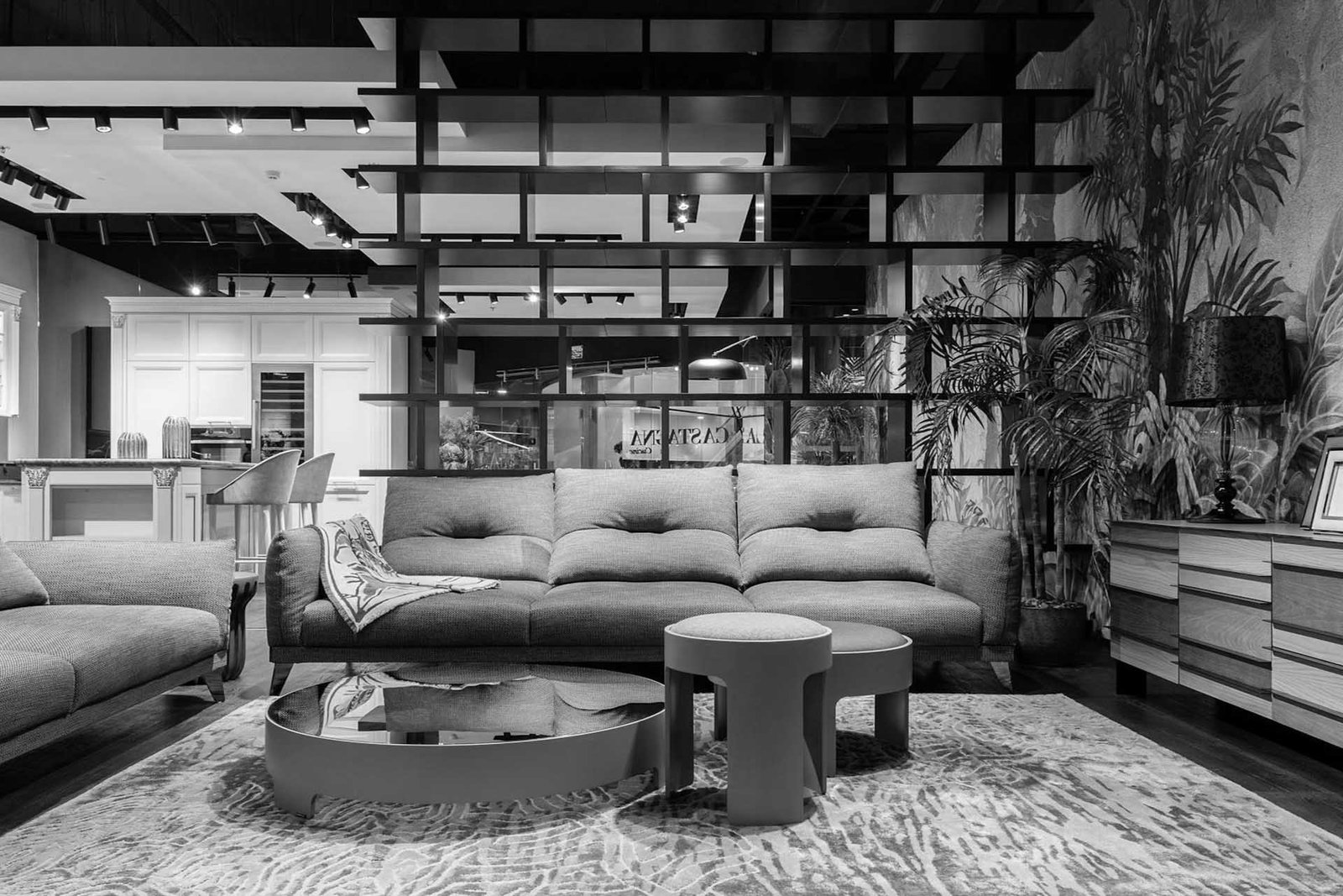 pexels-heyho-6969866 Modern living room with stylish furniture, open kitchen, and decorative shelving.